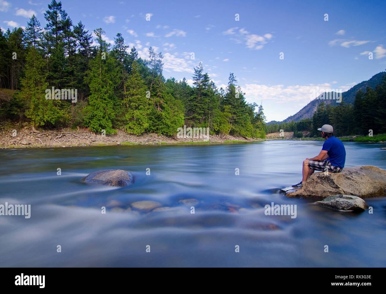 Uomo si siede accanto al fiume Similkameen, vicino Hedley, British Columbia, Canada - ritratto di auto Foto Stock