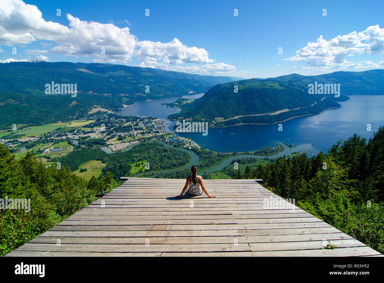 La donna gode di una straordinaria estate viewscape dalla rampa di parapendio che si affaccia Sicamous, il fiume Eagle e Shuswap Lake in British Columbia, Canada - MR1 Foto Stock