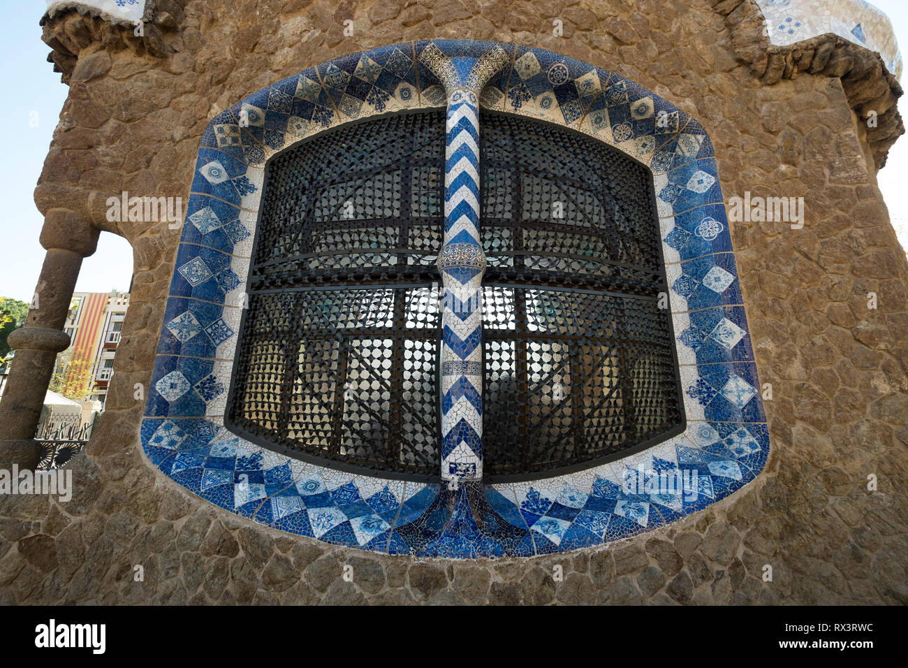 Un elaborato ferro piastrelle e finestra di lavoro in uno di Gaudí al Parco Guell di Barcellona, Spagna Foto Stock