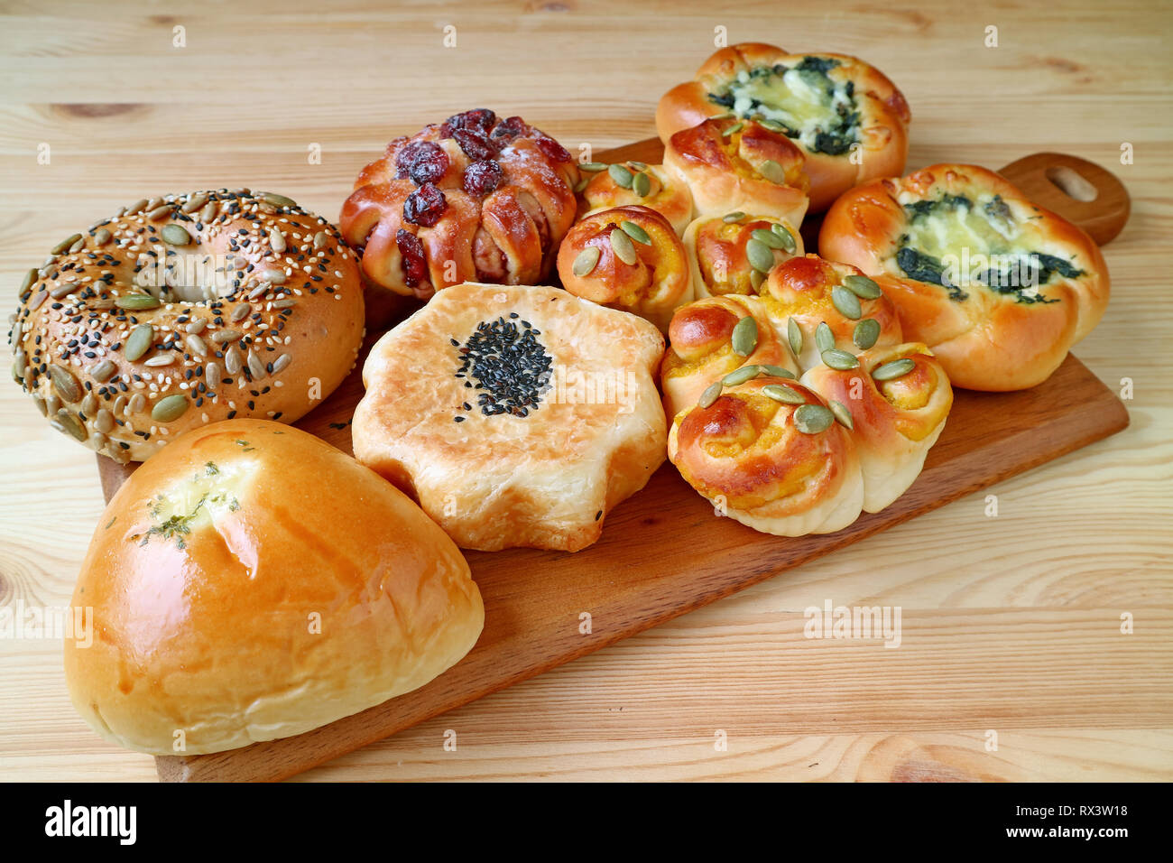 Un assortimento di panini e dolci sul vassoio in legno servita su un tavolo di legno Foto Stock