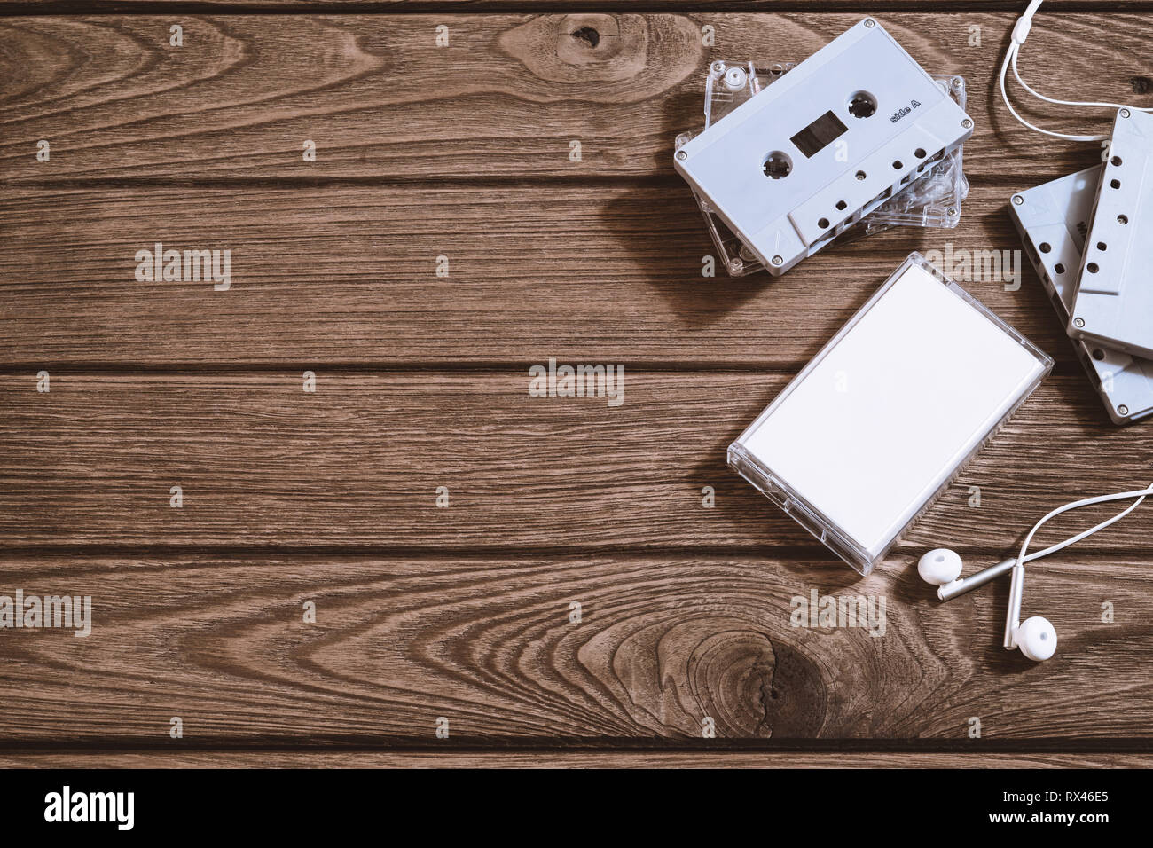 Colpo di overhead di retro vecchia cassetta audio tape con auricolare su vintage retrò sfondo di legno, laici flat top view con copia spazio. Foto Stock