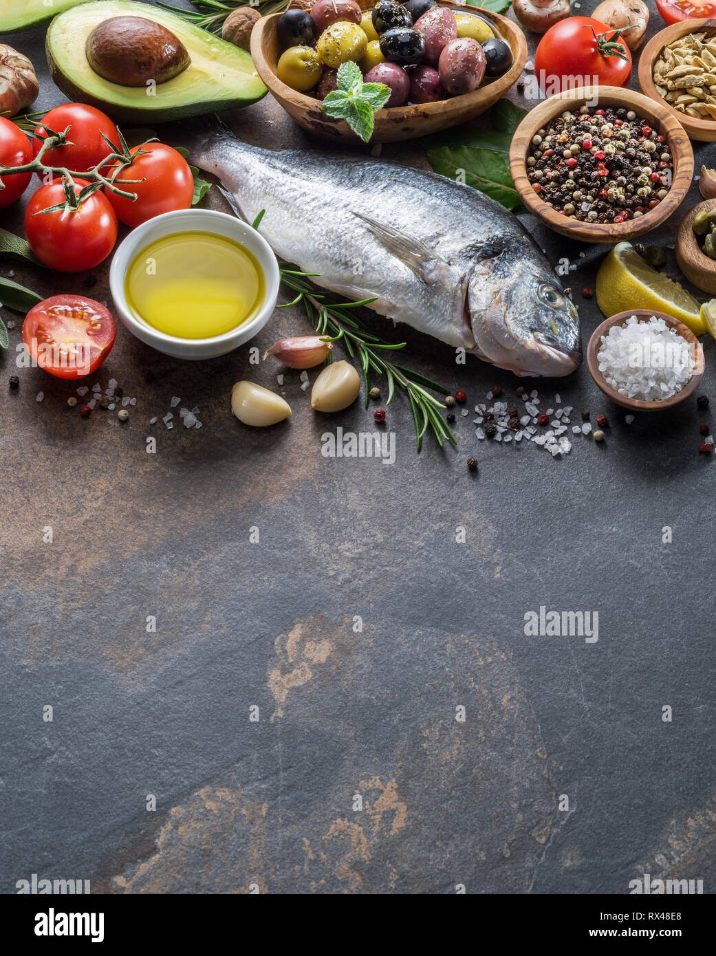Materie dorado pesce con spezie e verdure sulla scheda di grafite. Vista dall'alto. Foto Stock