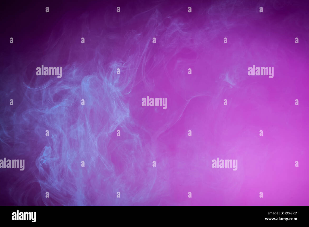 Nebbia colorata con blu brillante di gel scuro su sfondo rosa Foto Stock