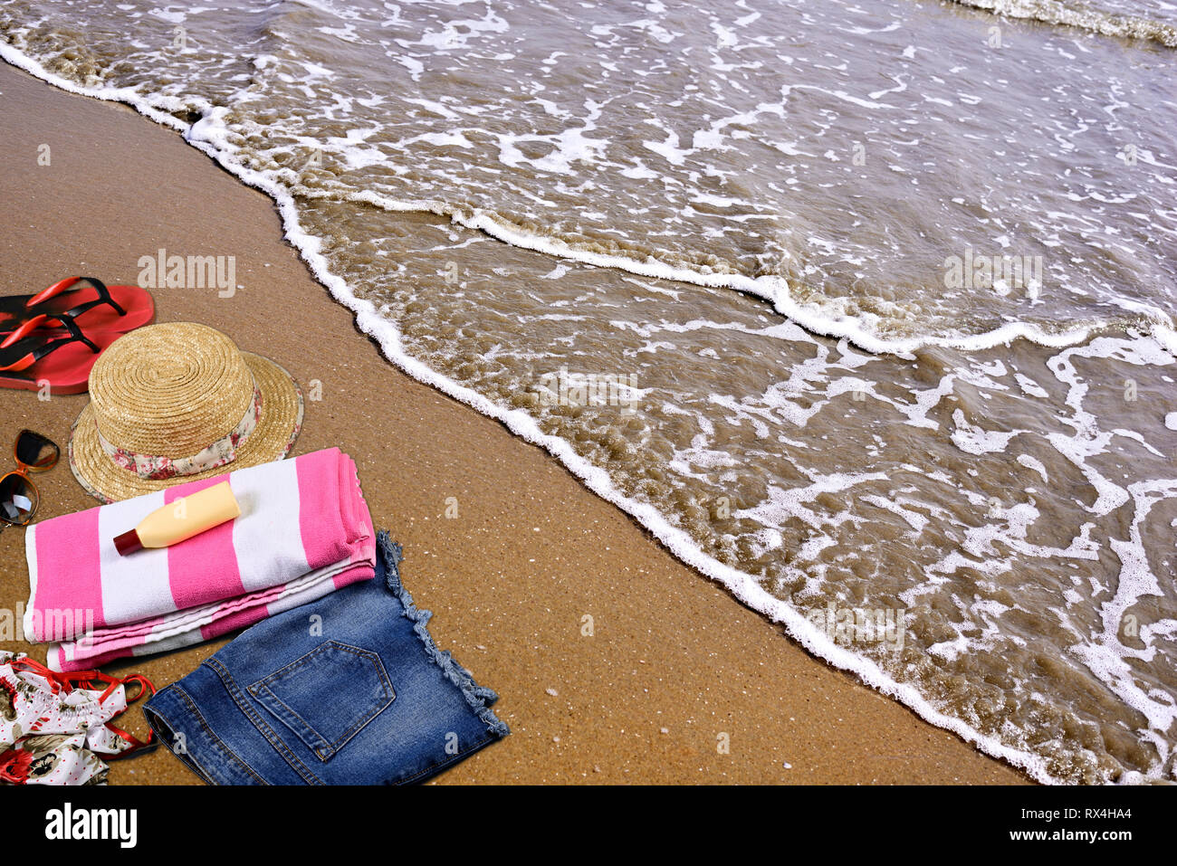 Estate spiaggia accessori posa sulla sabbia nel vuoto mare spiaggia Foto Stock