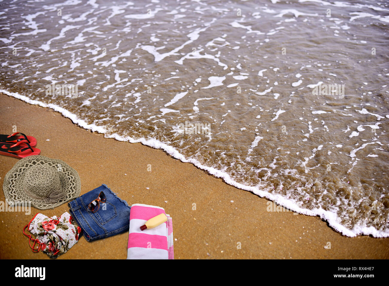 Estate spiaggia accessori posa sulla sabbia nel vuoto mare spiaggia Foto Stock