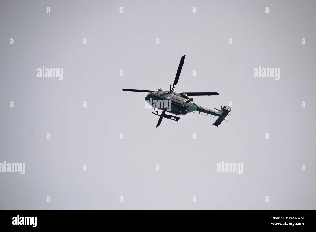 Un elicottero militare visto planare nel cielo durante le restrizioni in Srinagar Kashmir. Le autorità impongono delle restrizioni in parti della città in vista di un strike chiamato dai separatisti contro slapping della pubblica sicurezza atto (PSA) sul presidente JKLF Yasin Malik e divieto di Jaamat-e-Islami (JeI). Foto Stock