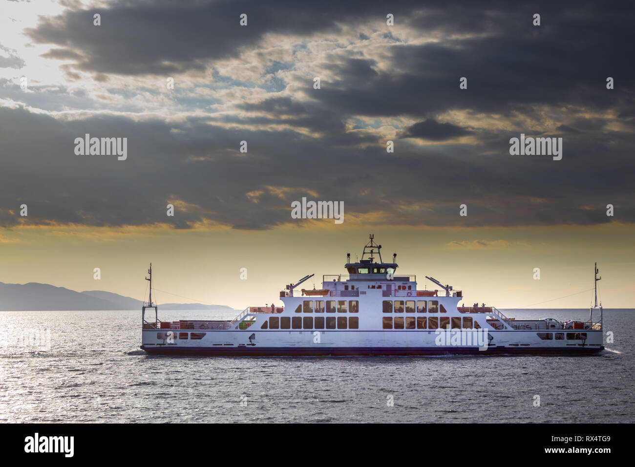 Traghetto ferry boat sul mare, cielo nuvoloso tramonto sul mare Foto Stock