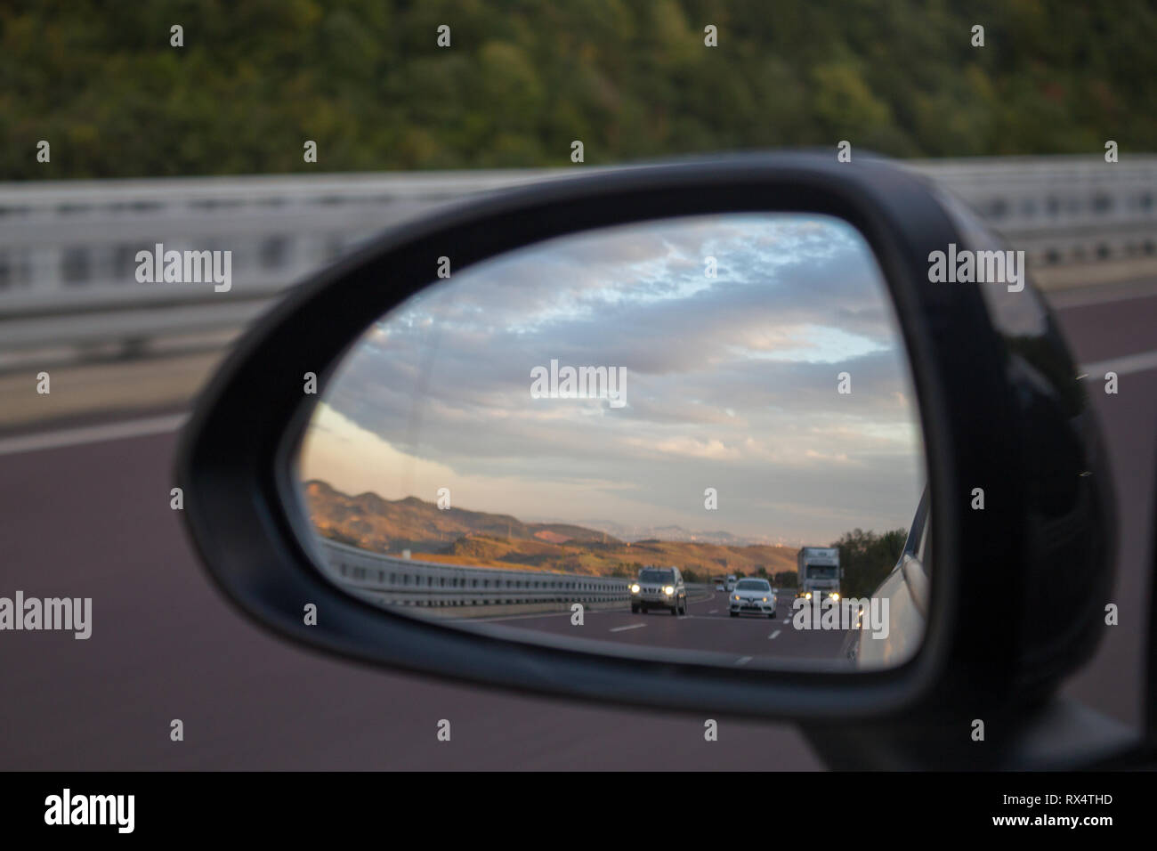 Autostrada vista dall'auto specchio retrovisore Foto Stock