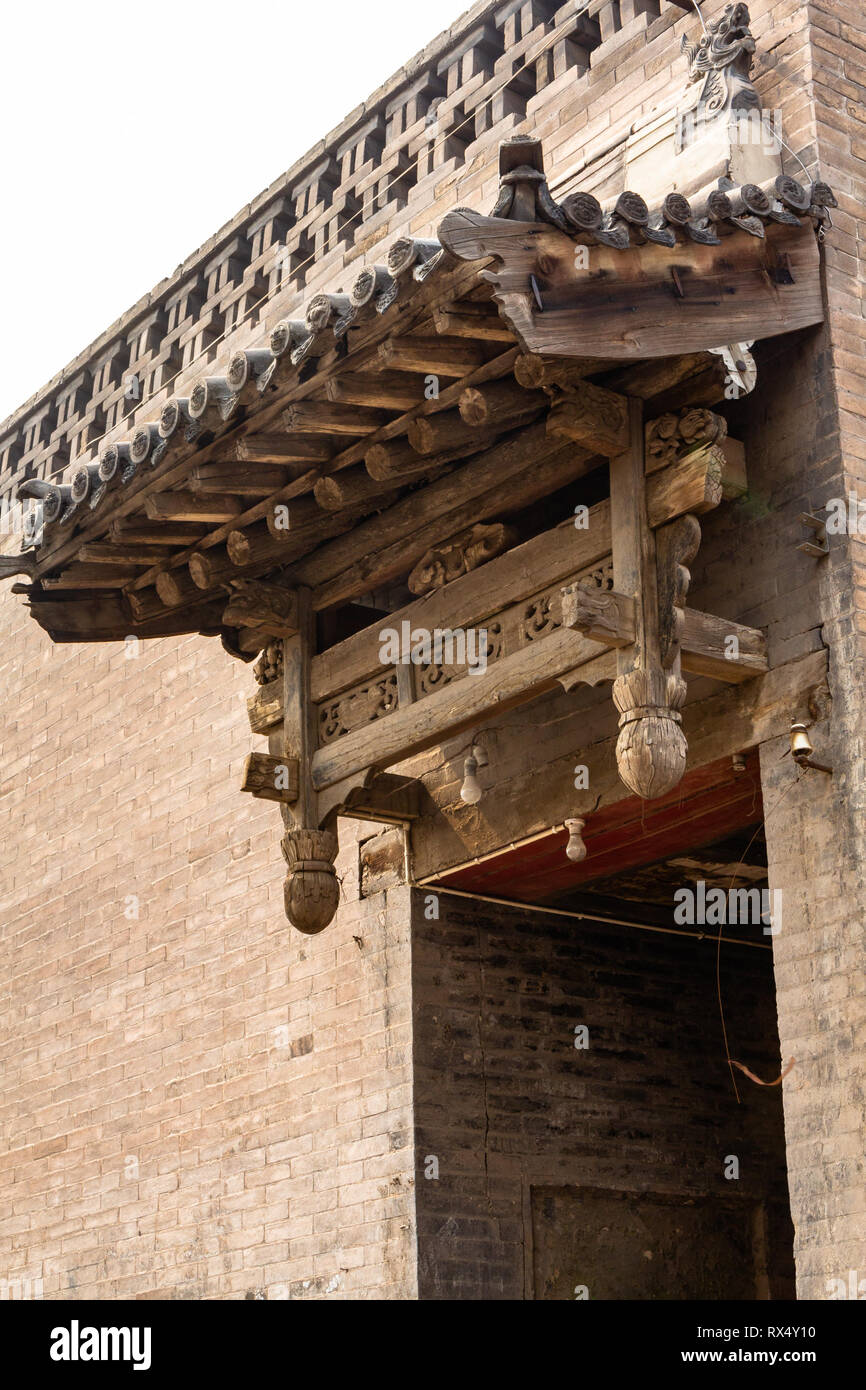 Uno dei tipici in legno decorazioni scolpite sopra le porte di entrata di Pingyao Città Antica, nella provincia di Shanxi, Cina. Di Pingyao è un patrimonio mondiale UNESCO Foto Stock