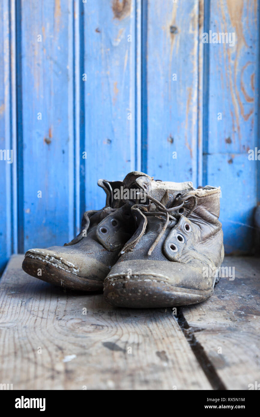 Vecchio indossato stivali sul pavimento Foto Stock