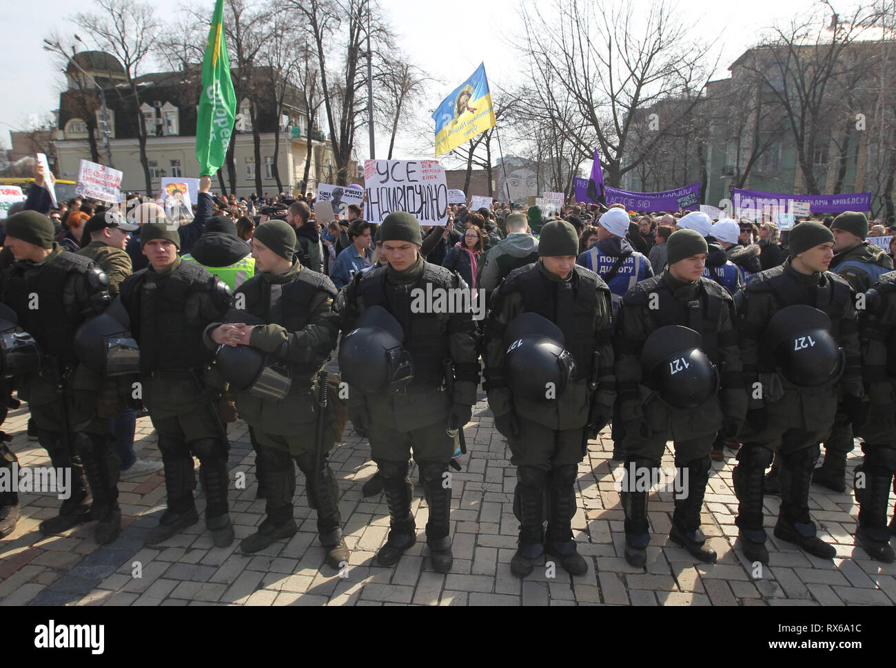 Ukrainian guardie nazionali sono visto in piedi in guardia durante la protesta. Le femministe ucraine e i loro sostenitori hanno tenuto il loro marzo impegnativo per i diritti delle donne in tutto il mondo e contro la violenza domestica durante la giornata internazionale della donna che si celebra ogni anno il 8 marzo. Foto Stock