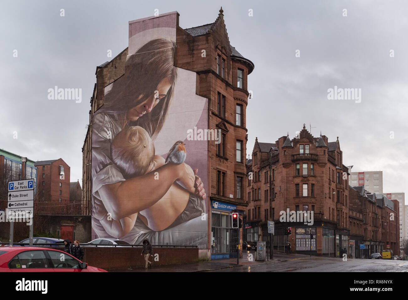 Glasgow - murale sul lato del tenement edifici di St Mungo, il santo patrono e fondatore di Glasgow come un bambino, Scotland, Regno Unito Foto Stock