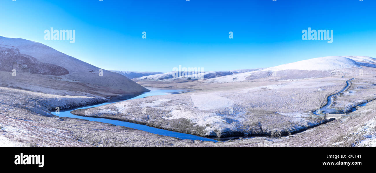 Elan Valley in Galles mostra Afon Elan fiume che scorre attraverso un panorama innevato di una scena invernale delle montagne e il cielo blu. Foto Stock