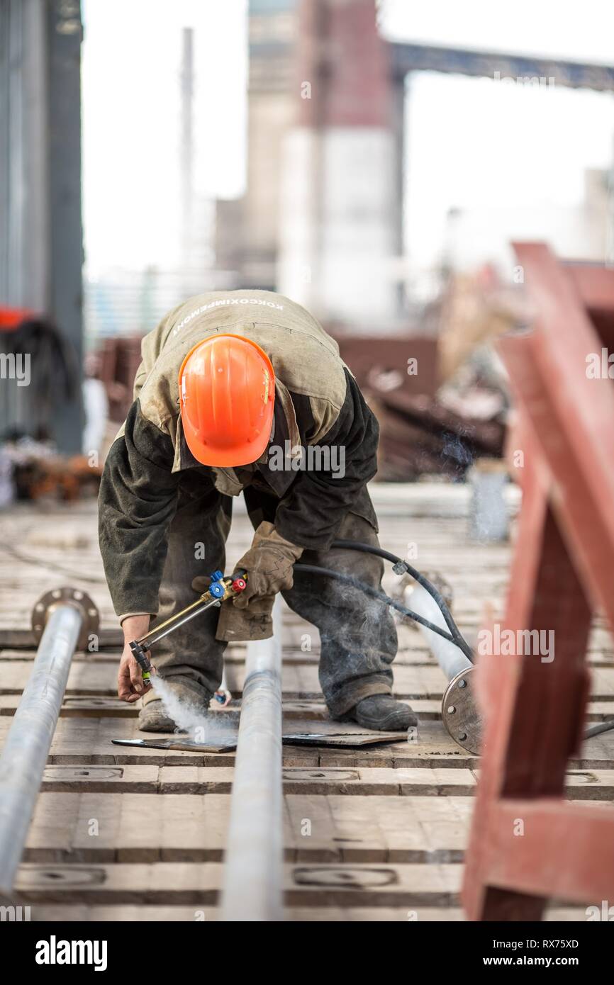 Lavoratori in fabbrica a Koksokhim, saldatrici sono impegnati nella costruzione ed installazione di strutture metalliche su terra alta e in lavorazioni speciali condi Foto Stock