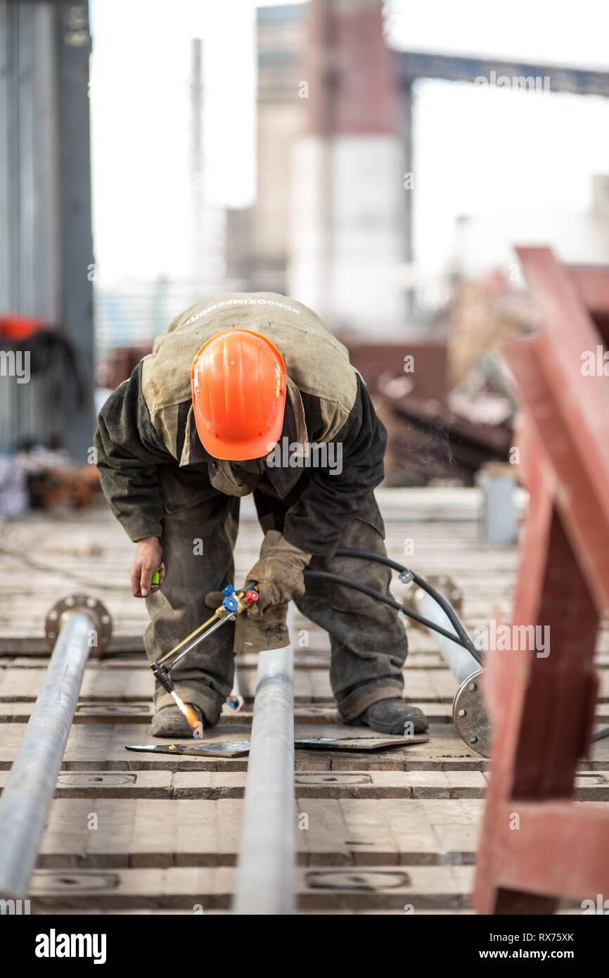 Lavoratori in fabbrica a Koksokhim, saldatrici sono impegnati nella costruzione ed installazione di strutture metalliche su terra alta e in lavorazioni speciali condi Foto Stock
