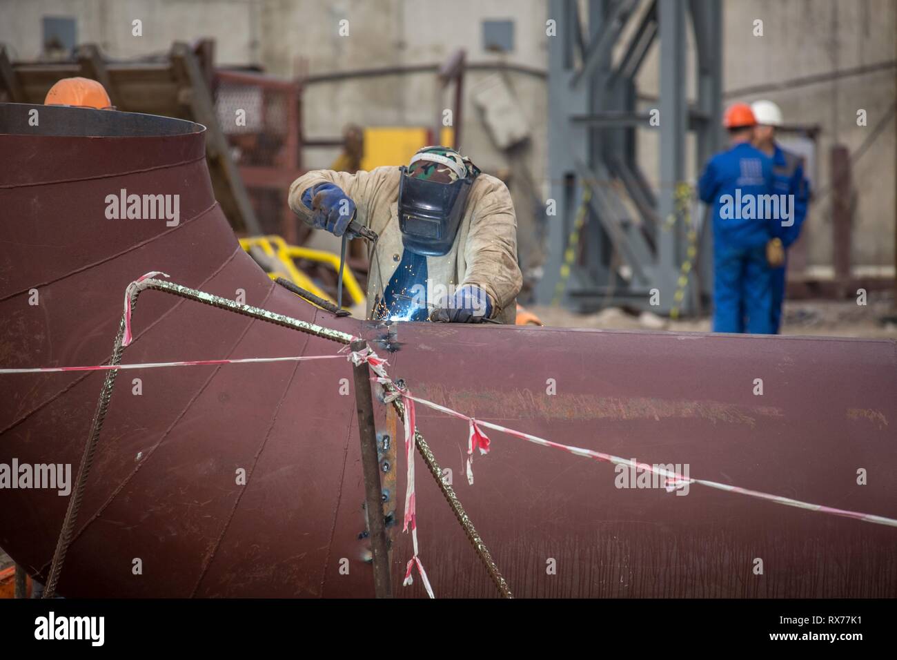 Lavoratori in fabbrica a Koksokhim, saldatrici sono impegnati nella costruzione ed installazione di strutture metalliche su terra alta e in lavorazioni speciali condi Foto Stock