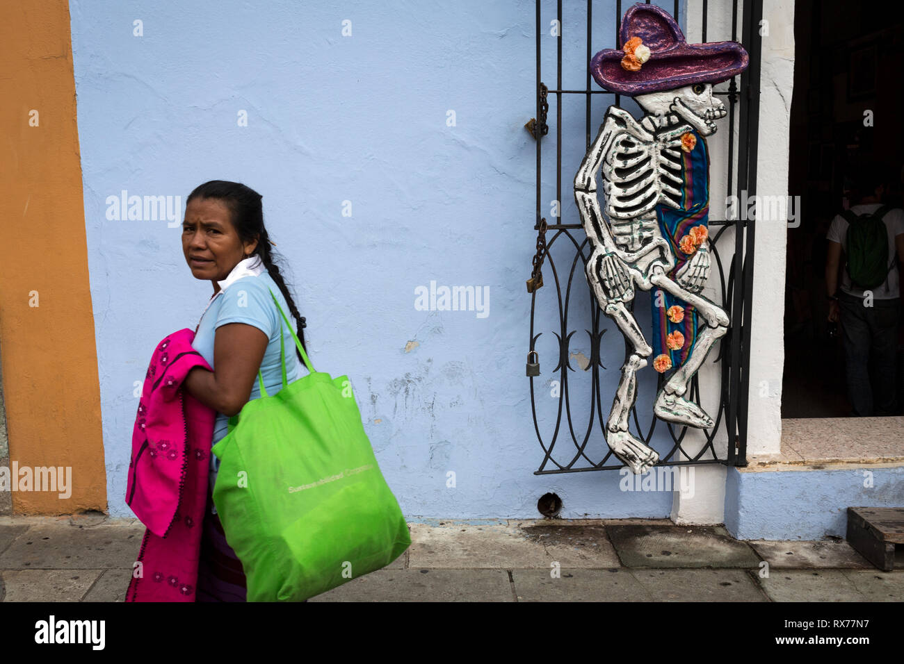 Una donna cammina davanti a una tenda decorata con uno scheletro durante la celebrazione del Giorno dei Morti. Foto Stock