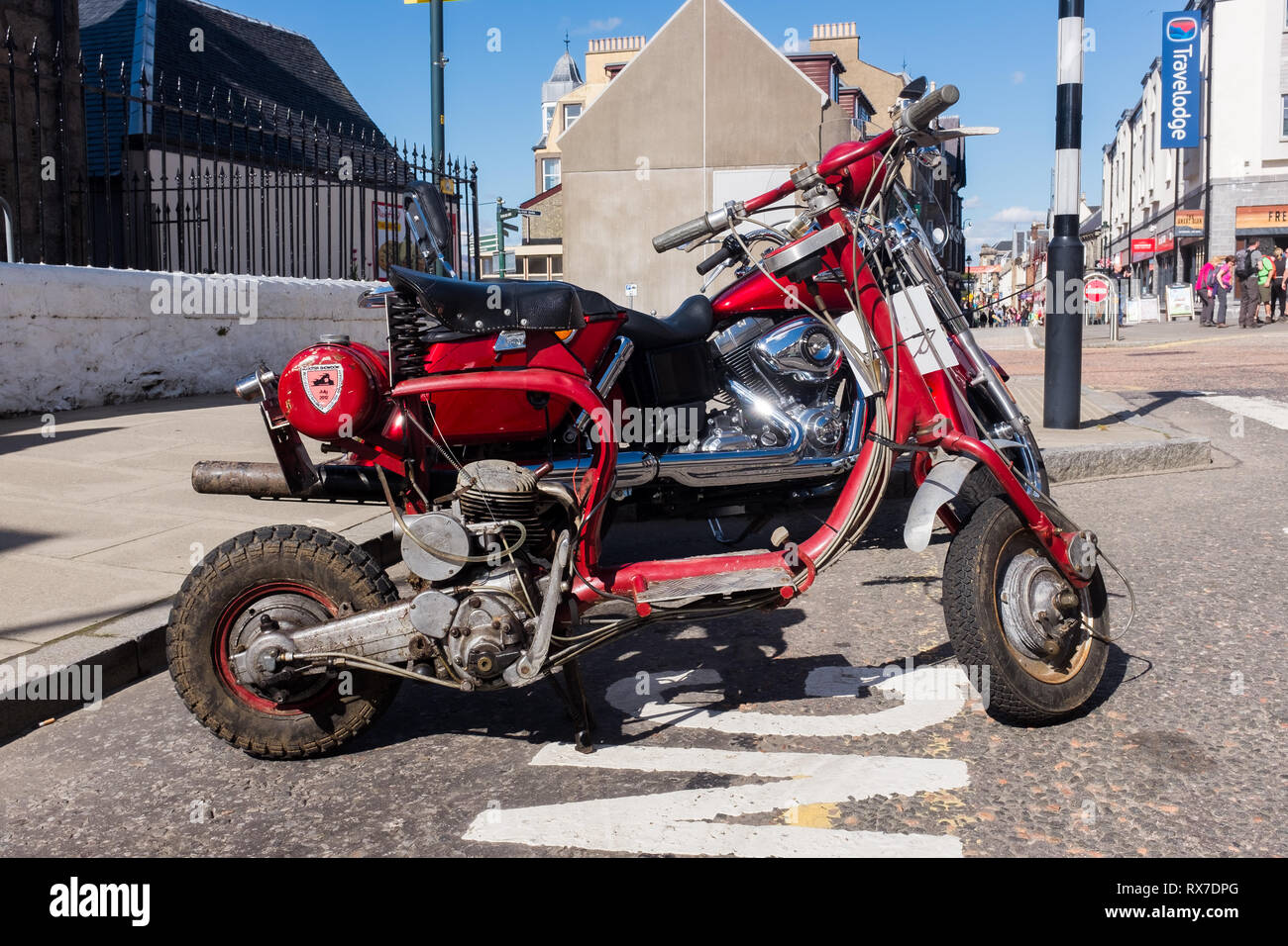 Parcheggiate rosso sporco media scooter a Fort William high street lochaber highlands scozzesi Scotland Regno Unito Foto Stock
