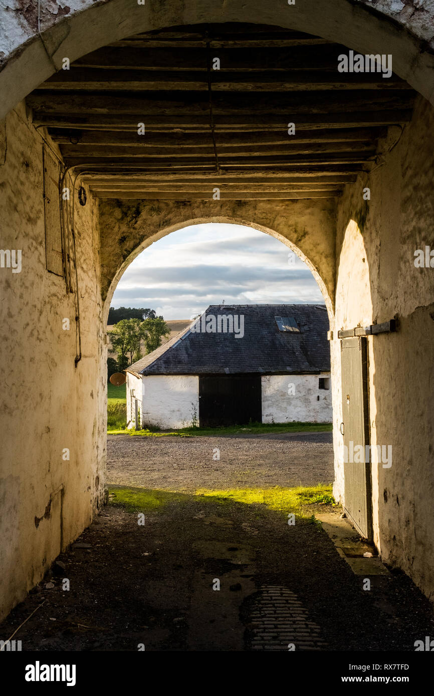 Guardando fuori attraverso l'apertura arcuata di una vecchia corte del bestiame e la trasformazione di fabbricati agricoli. Fattoria Enterkine ayrshire Scotland Regno Unito Foto Stock