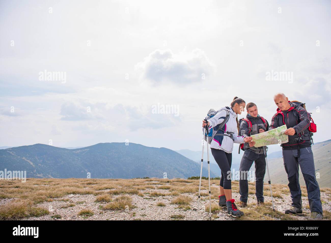 Avventura, viaggi, turismo, escursione e concetto di persone - gruppo di amici sorridente con zaini e mappa all'aperto Foto Stock