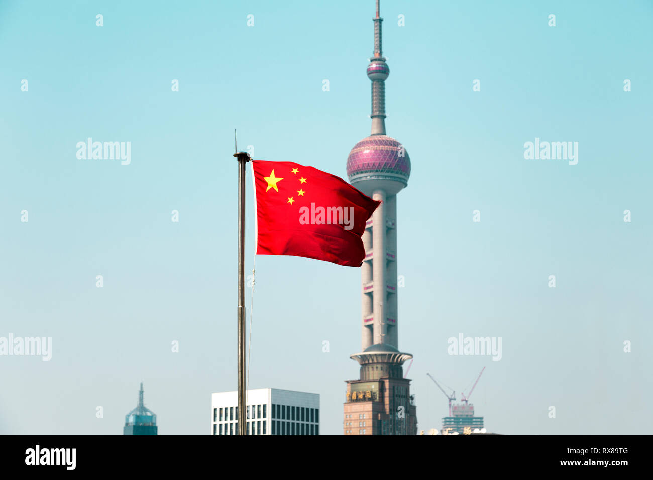 La bandiera cinese soffia il vento. Dietro di essa la Oriental Pearl Tower una struttura di pietra miliare di Shanghai. Il Pudong, Shanhai, Cina. Foto Stock
