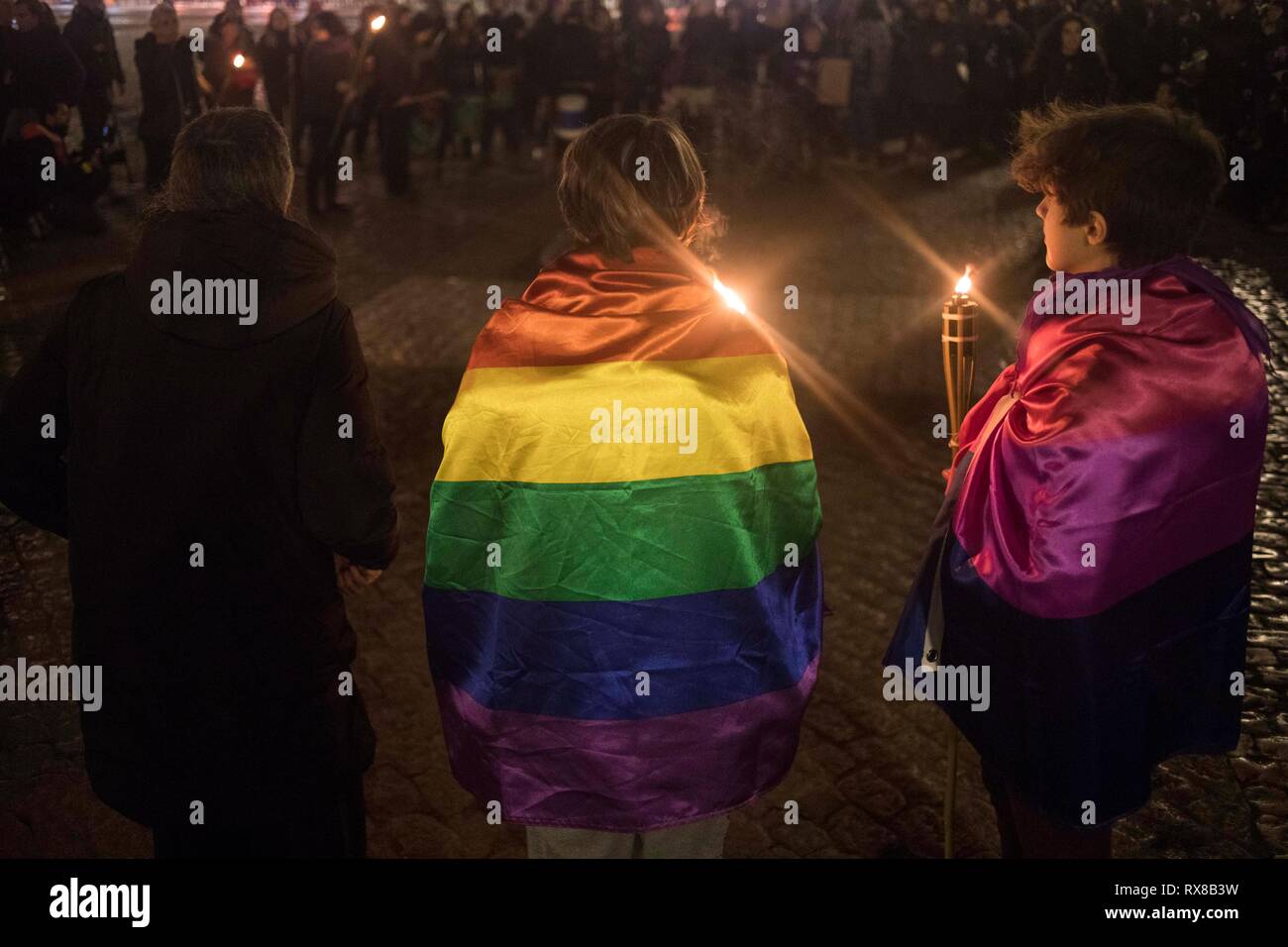 Una donna è visto tenendo una candela con la bandiera LGTB durante lo sciopero. Diverse donne sciopero durante la giornata internazionale delle donne contro la violenza di genere. Foto Stock