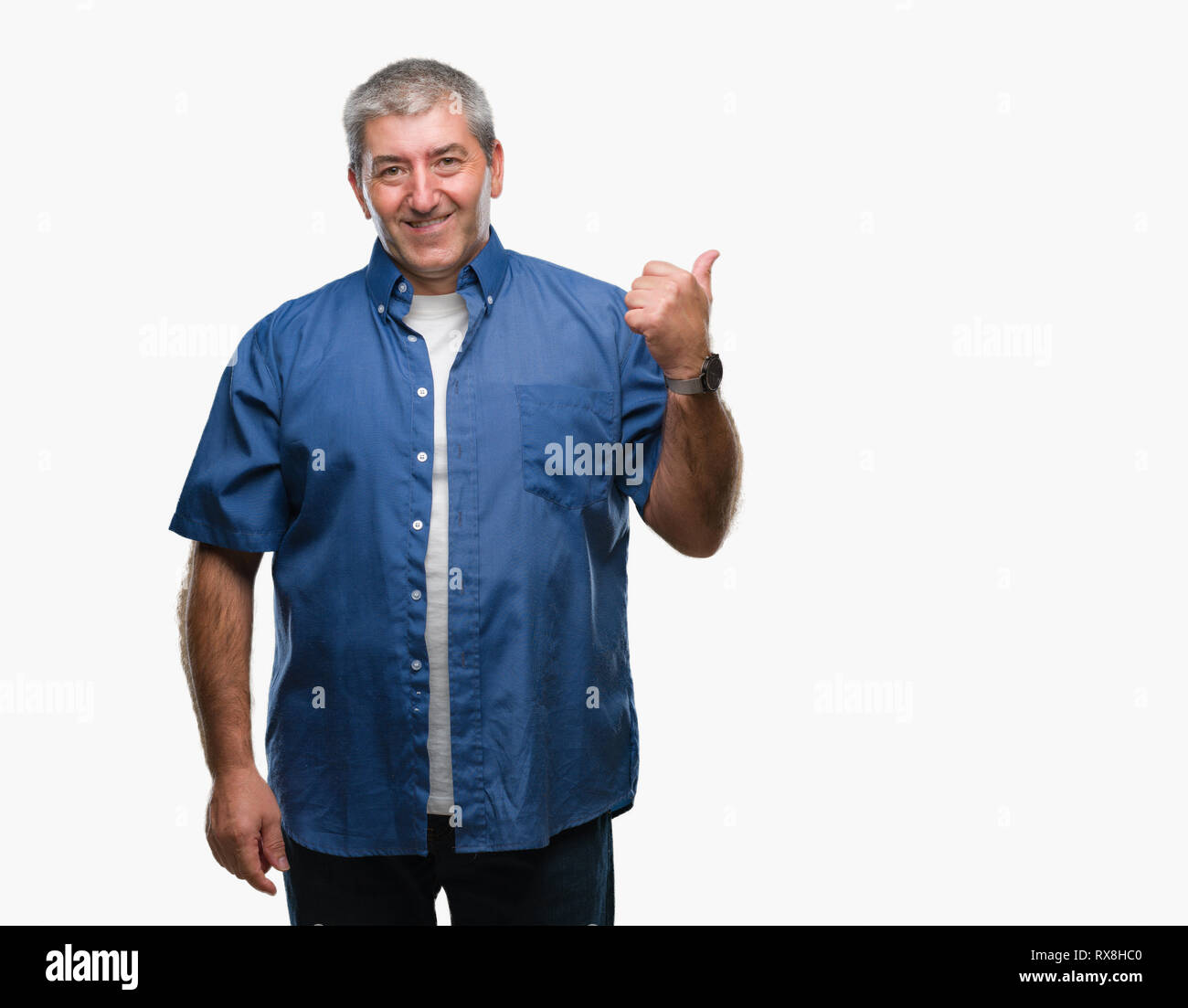 Bello il senior uomo su sfondo isolato sorridente con la faccia felice alla ricerca e rivolta verso il lato con il pollice verso l'alto. Foto Stock