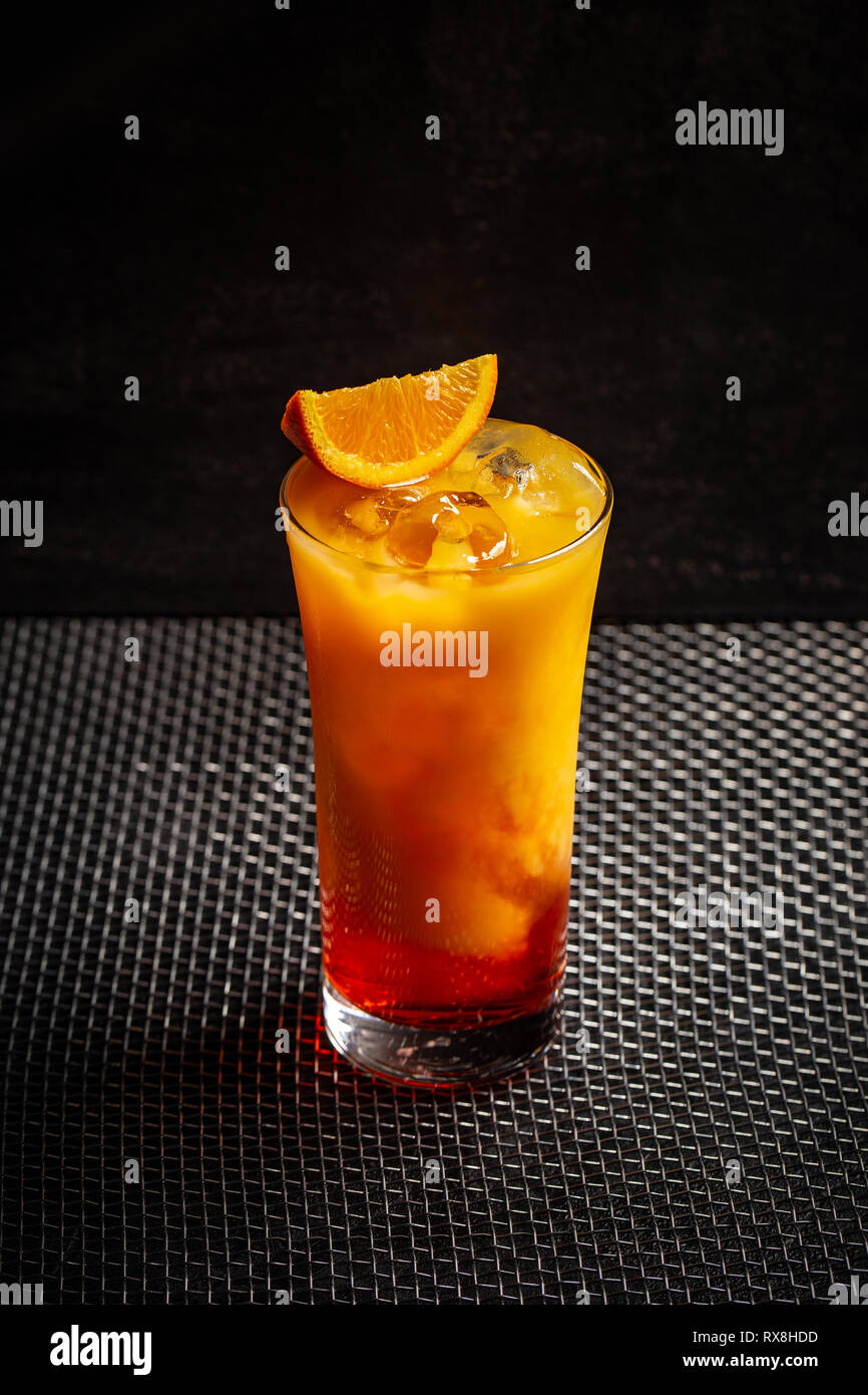 Bicchiere di aperol cocktail di colore arancione su sfondo nero Foto Stock