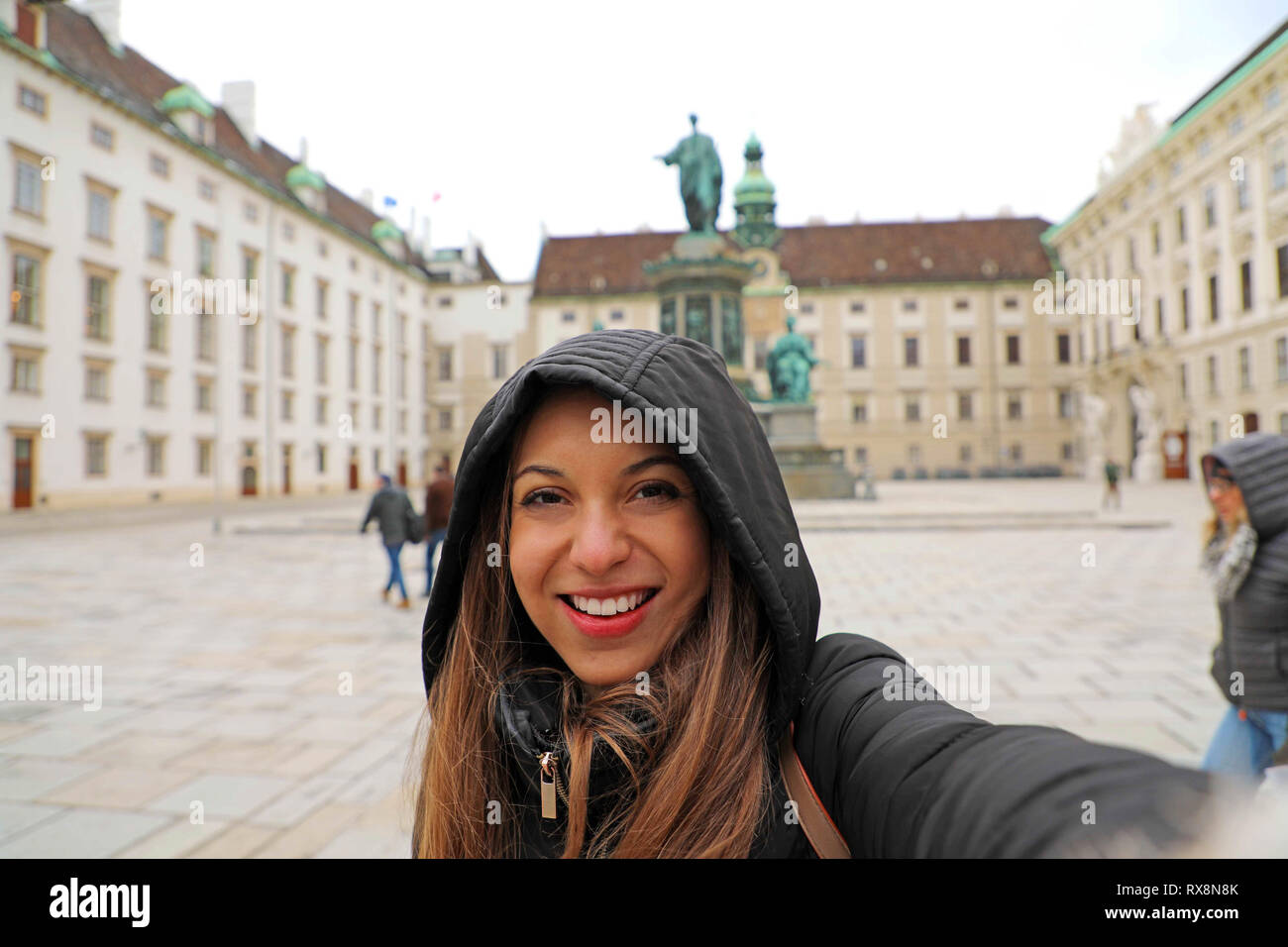 Felice donna sorridente a Vienna nel periodo invernale. Viaggi in Europa ragazza prendere ritratto di auto nel cortile di Hofburg di Vienna in Austria. Foto Stock