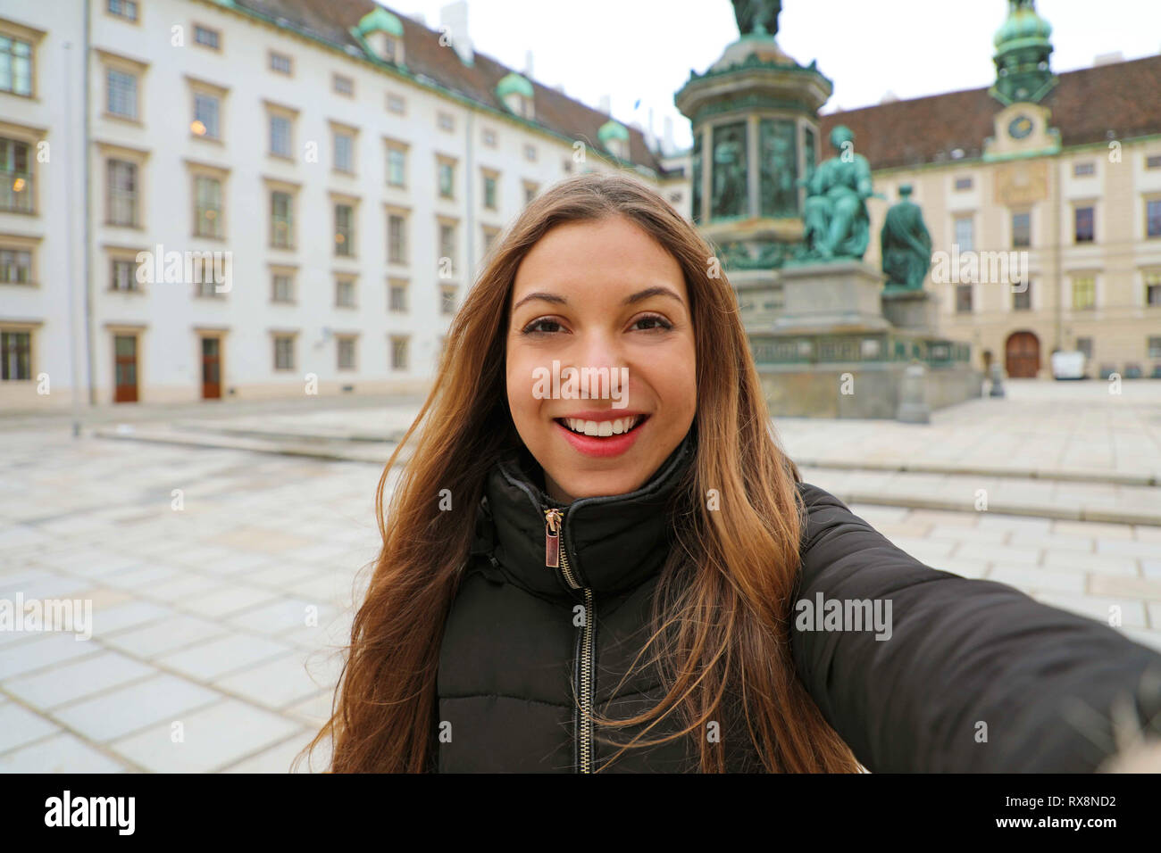 Felice Allegra donna a Vienna nel periodo invernale. Viaggi in Europa ragazza prendere ritratto di auto nel cortile di Hofburg di Vienna in Austria. Foto Stock