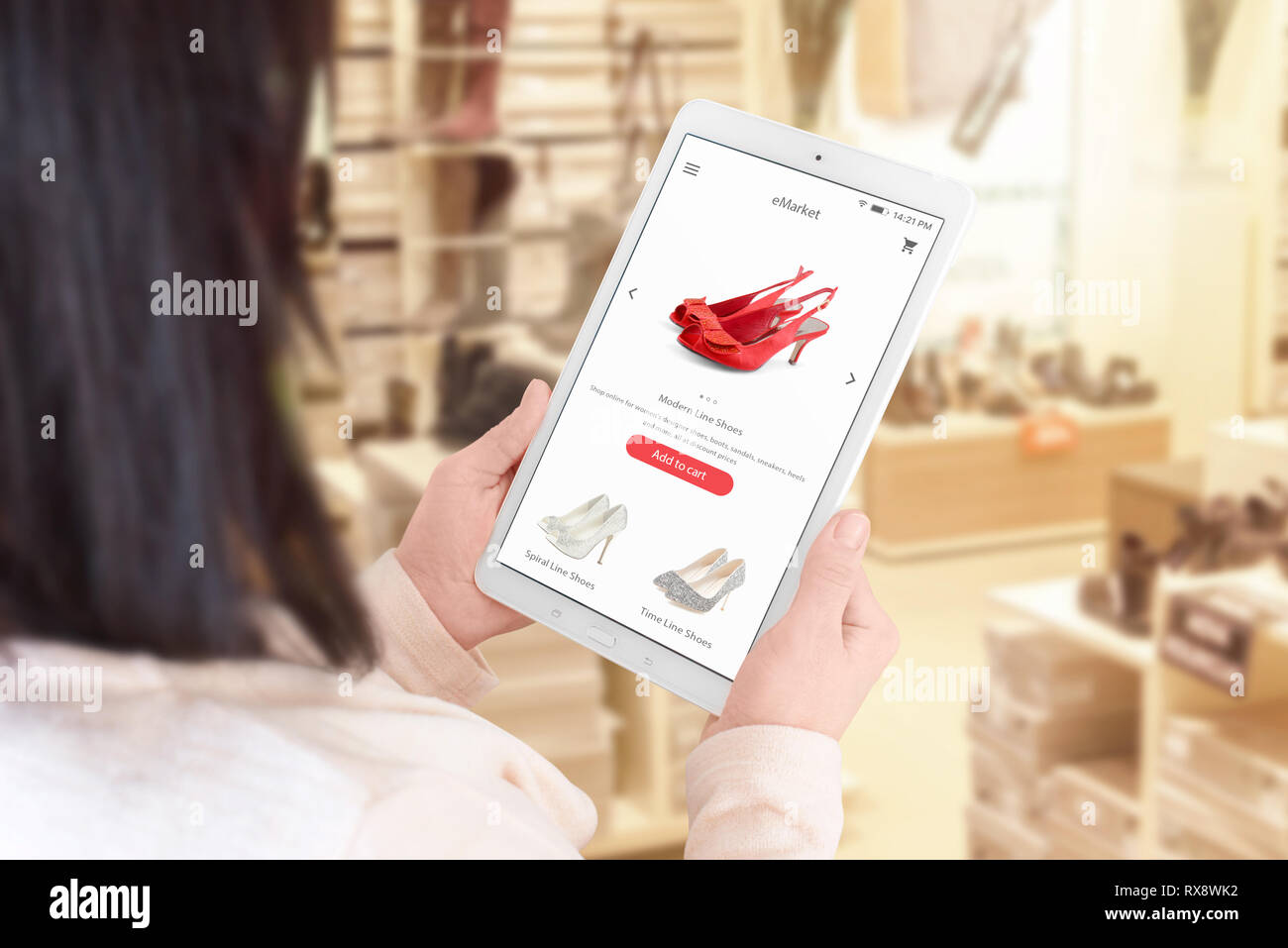 Shopping online app sui tablet display. Donna utilizzano tablet per la ricerca web site del ecommerce. Calzatura negozio in background. Foto Stock