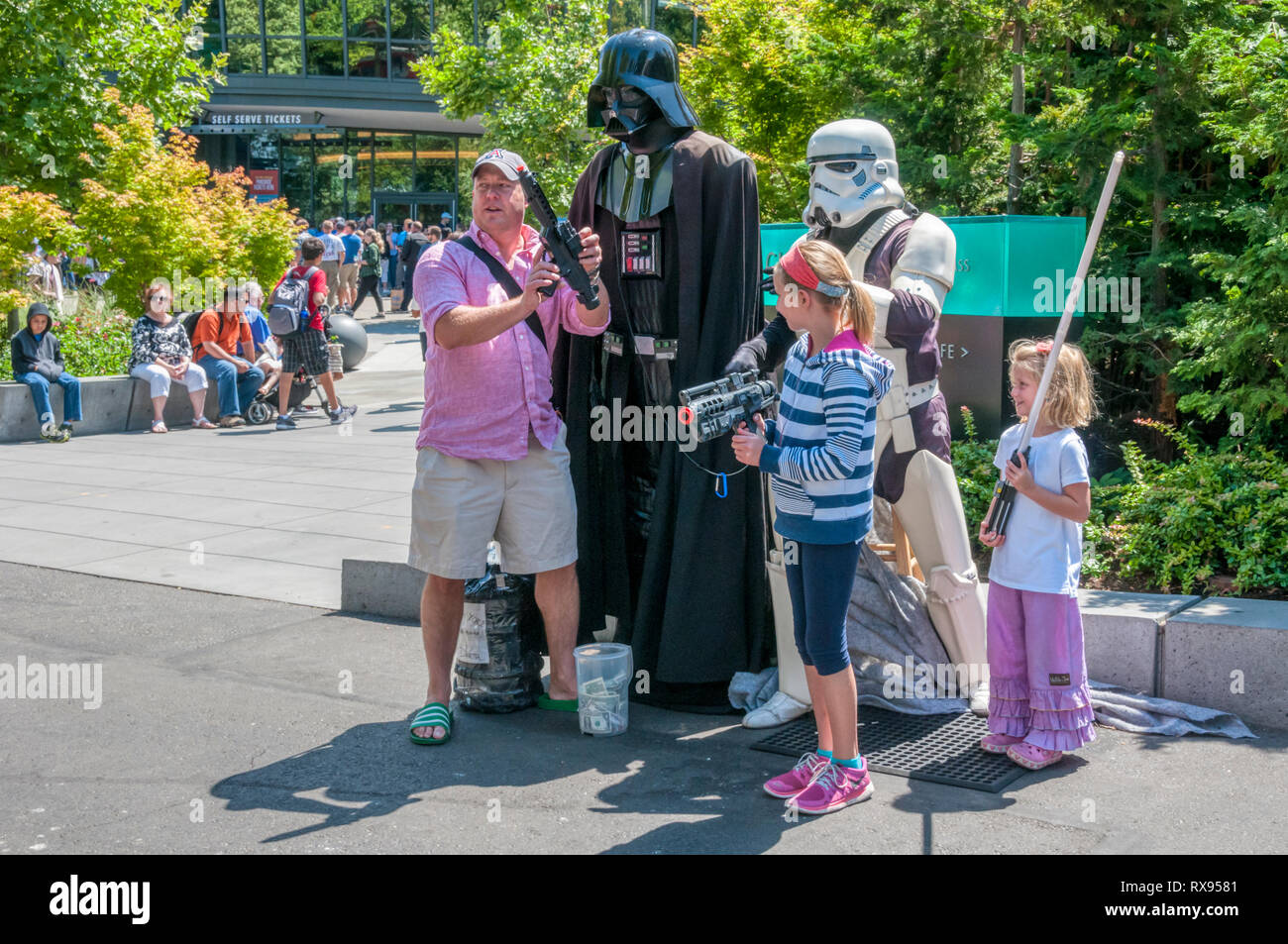 Una famiglia avente la loro fotografia scattata con Star Wars personaggi di Darth Vader & Imperial Stormtrooper costumi presso il centro di Seattle. Foto Stock
