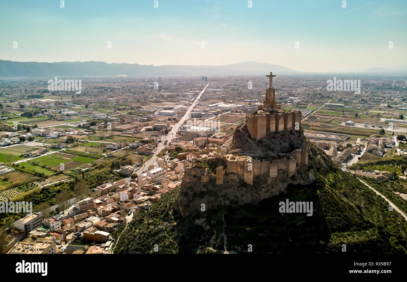 La fotografia aerea ampio angolo drone di punto di vista statua del Cristo sulla cima di una roccia calcarea Monteagudo castello-fortezza e la città di Murcia e Foto Stock