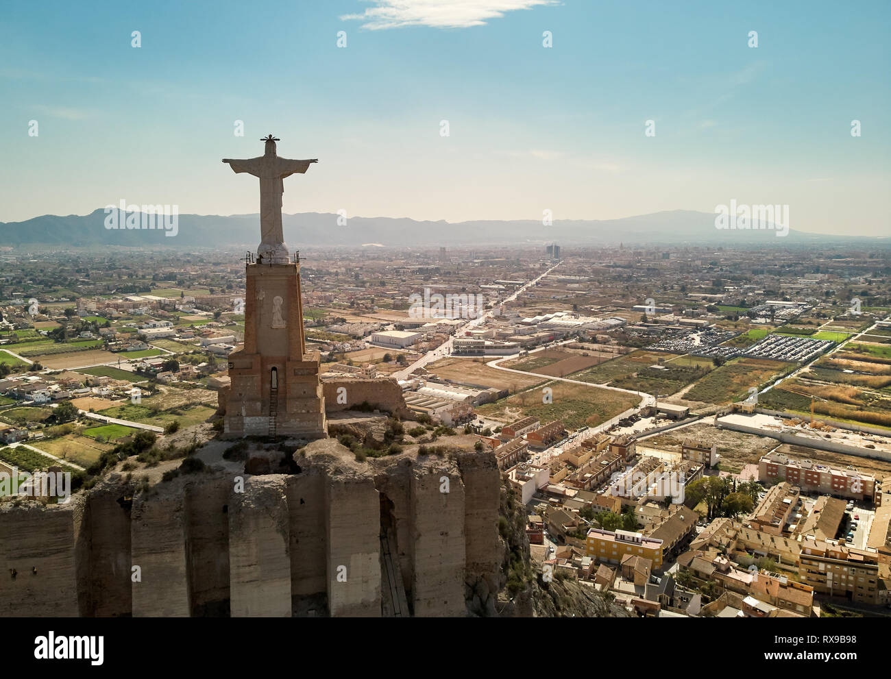 La fotografia aerea ampio angolo drone di punto di vista statua del Cristo sulla cima di una roccia calcarea Monteagudo castello-fortezza e la città di Murcia un Foto Stock