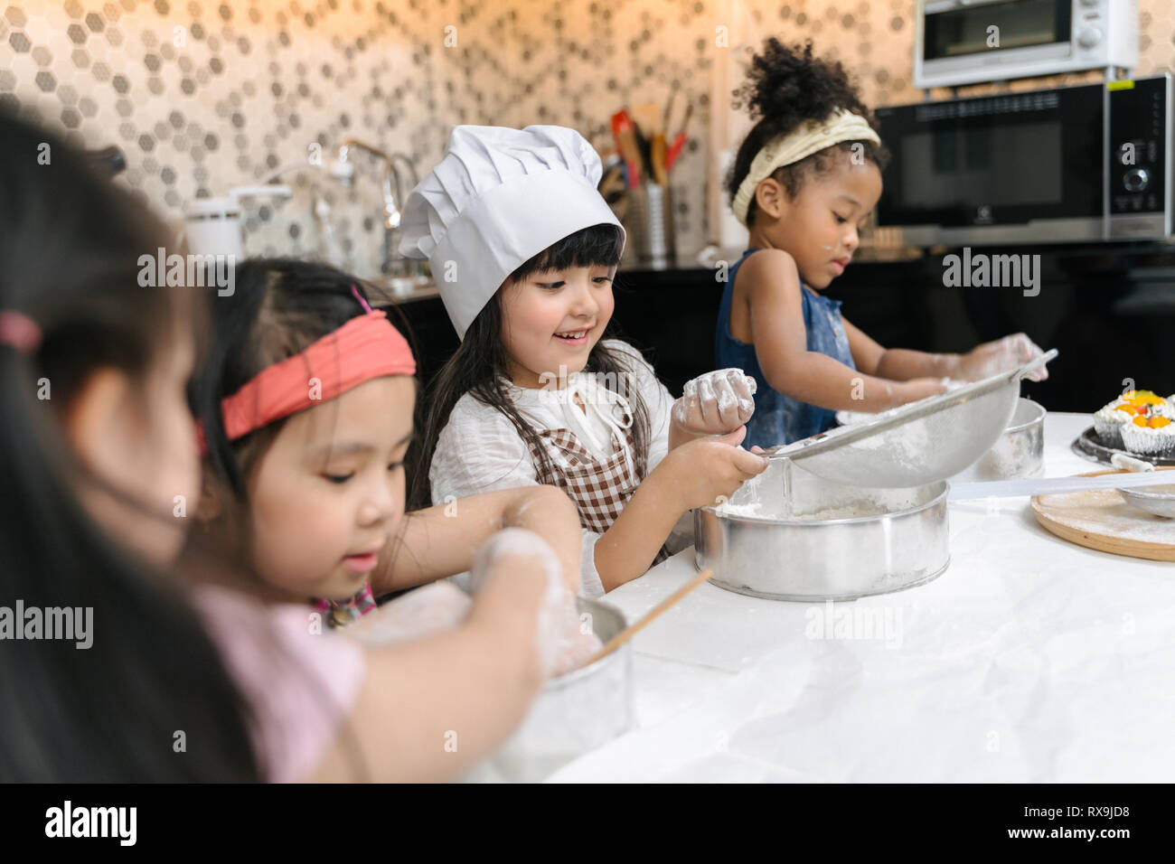 Gruppo di ragazzi stanno preparando il forno in cucina .i bambini ad  imparare a cucinare i cookie Foto stock - Alamy