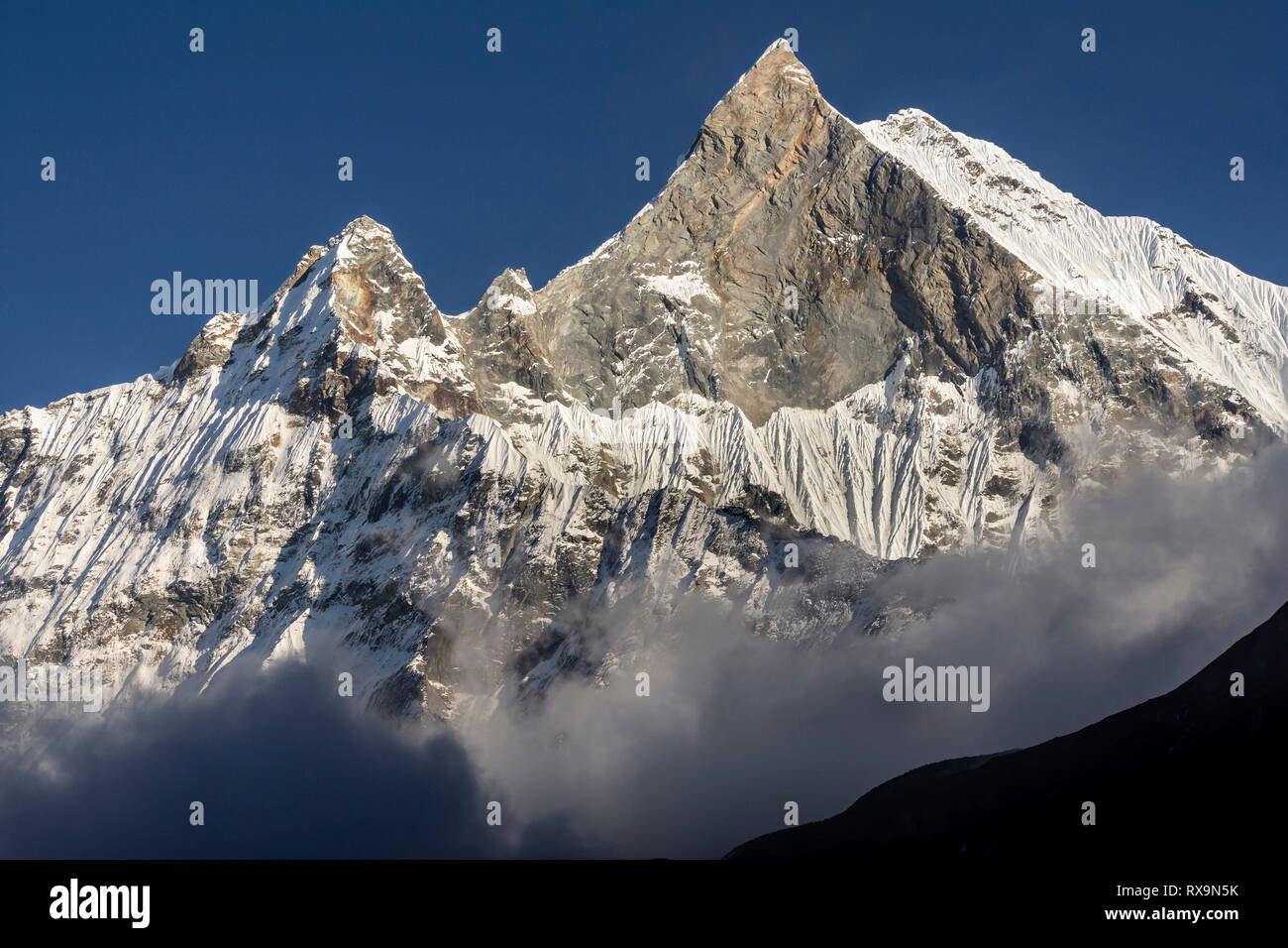 Vista panoramica del monte incappucciate di neve contro il cielo blu e chiaro durante la giornata di sole Foto Stock