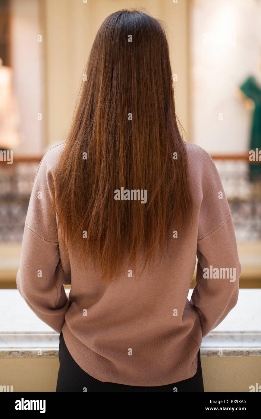 Femmina lunghi capelli ondulati, vista posteriore, brunette acconciatura, interni Foto Stock