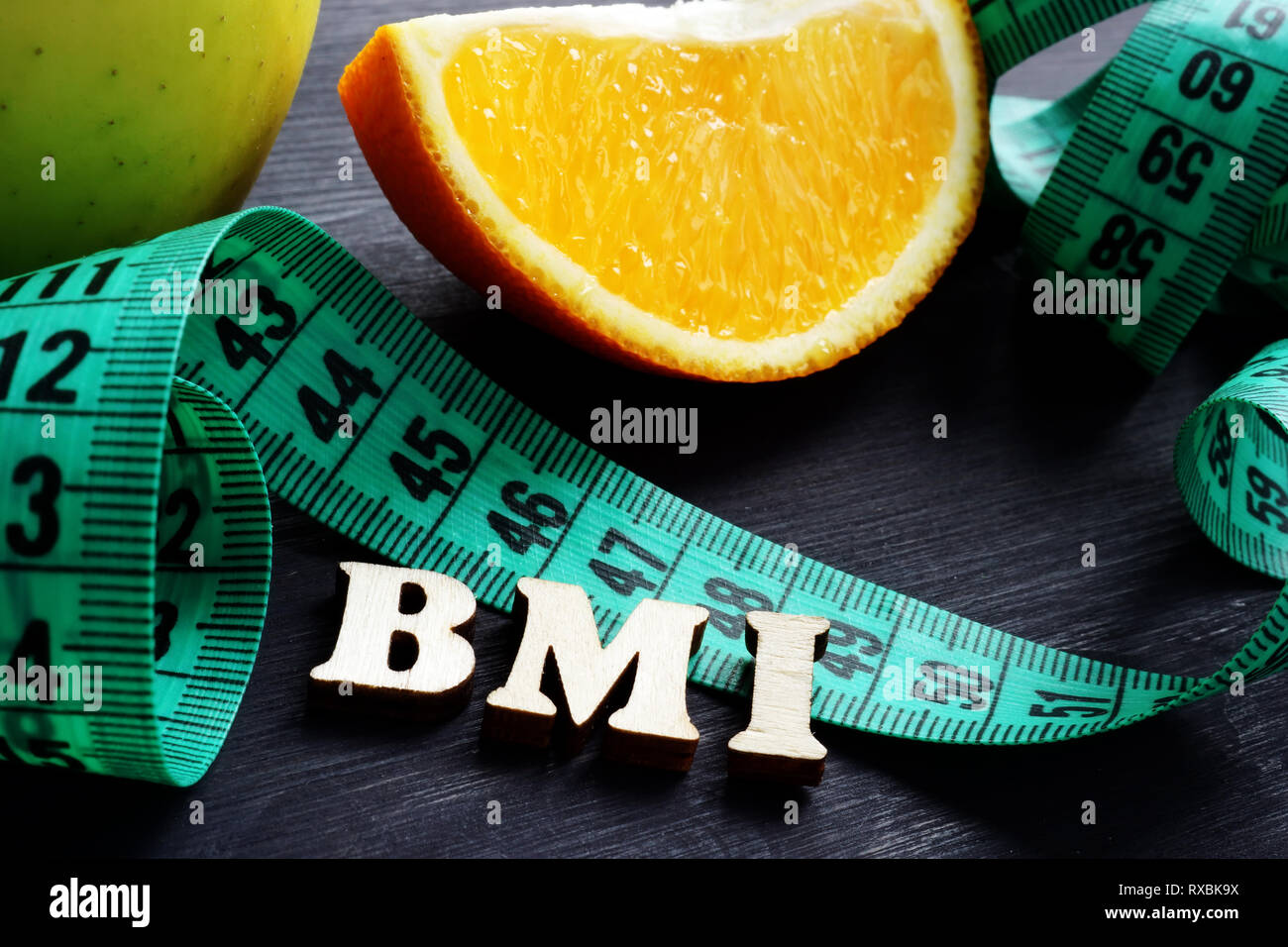 Lettere BMI indice di massa corporea con nastro di misurazione e arancione. Foto Stock