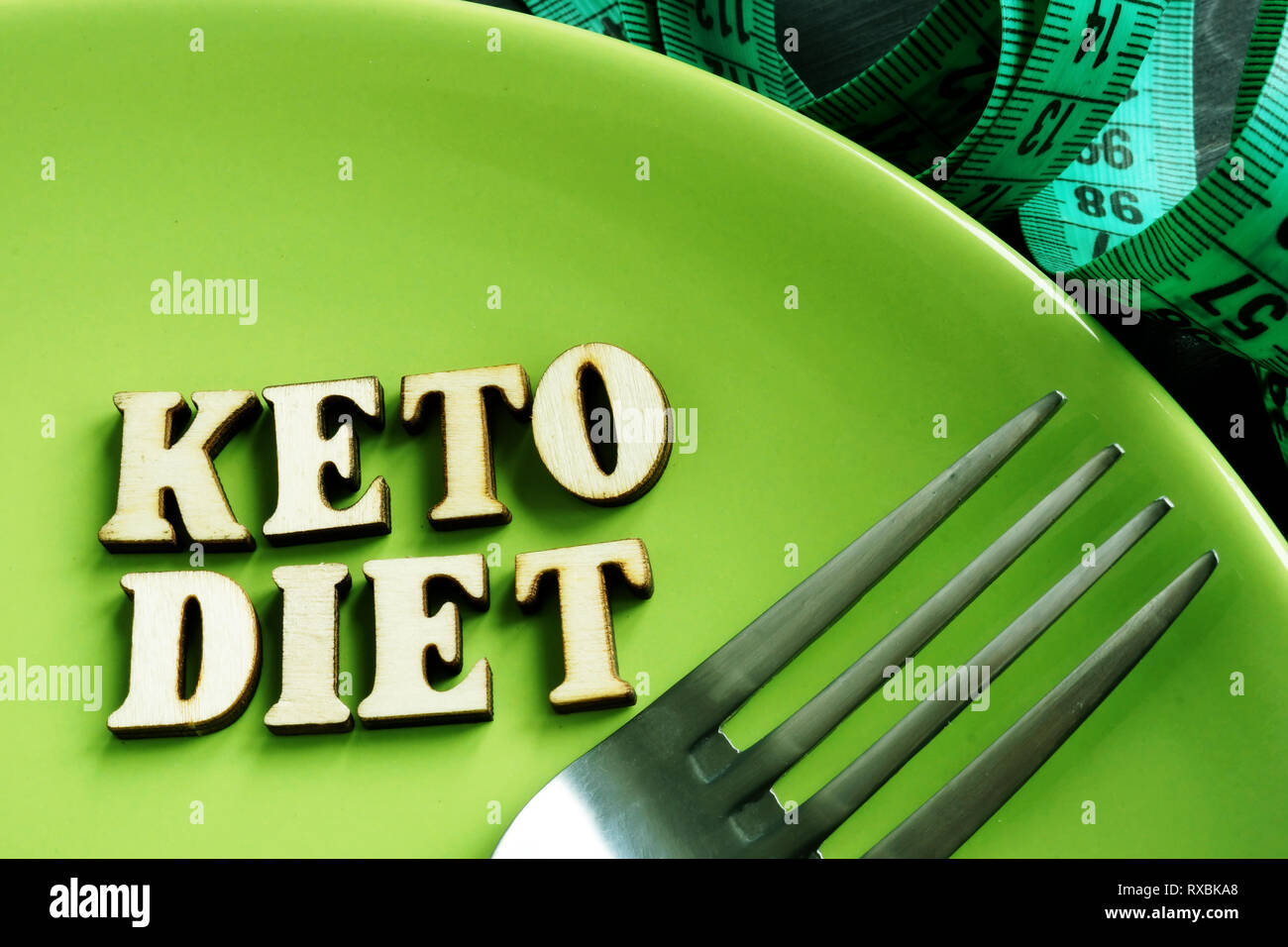 Dieta cheto su una piastra verde e nastro di misurazione. Foto Stock