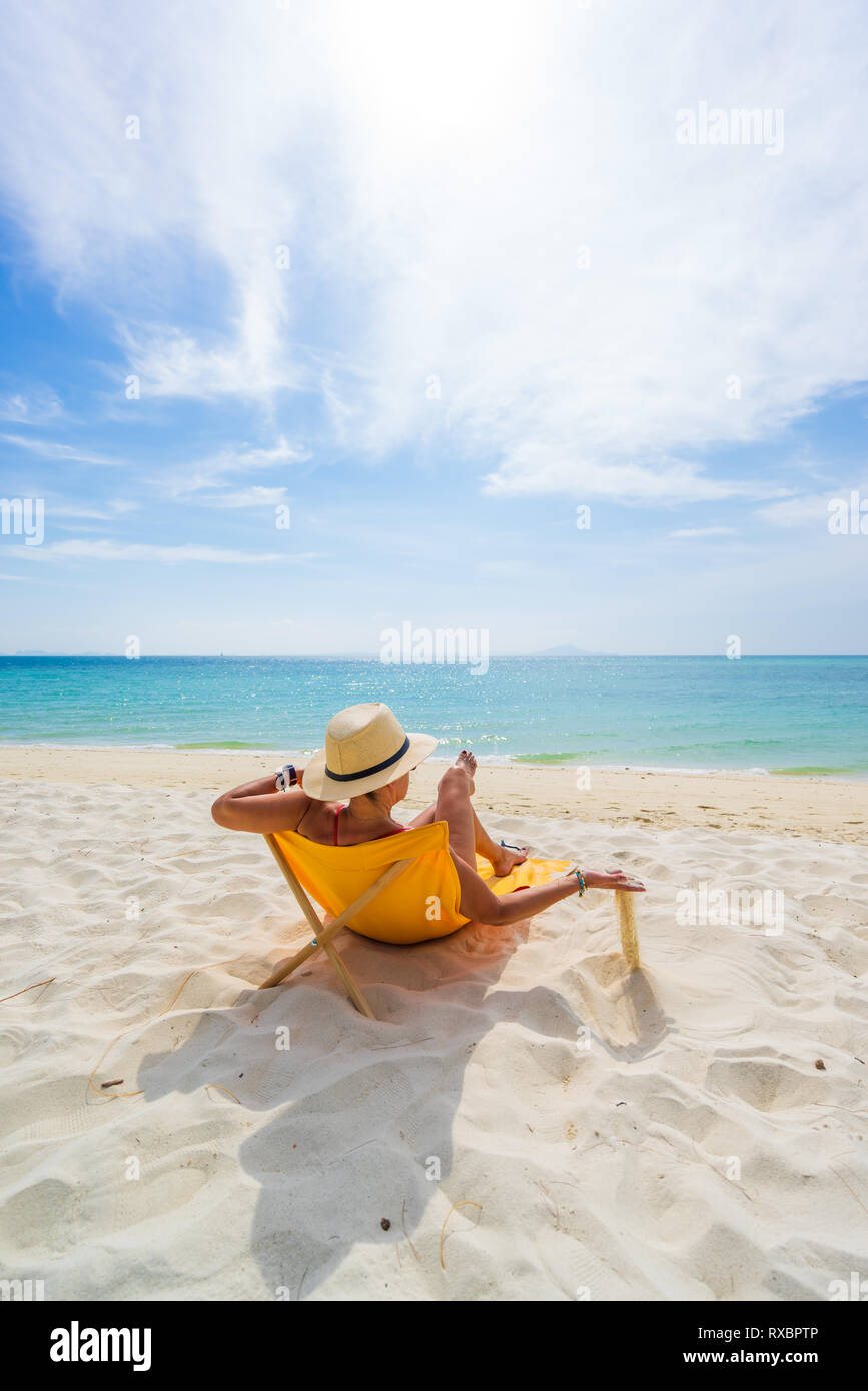 Donna con cappello di paglia godendo le vacanze su un transat presso la  spiaggia tropicale in Tailandia Foto stock - Alamy
