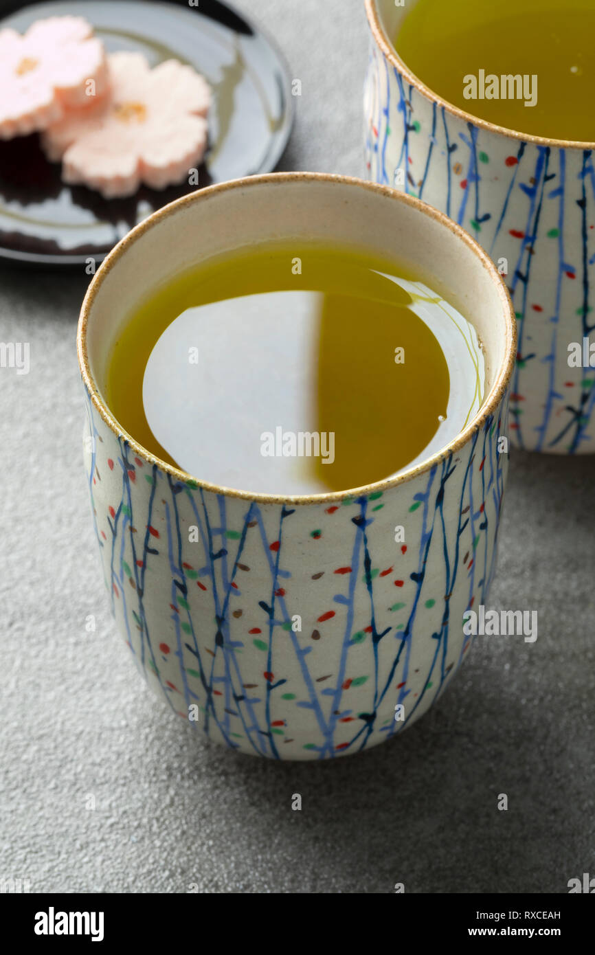Tazze con tradizionale caldo giapponese del tè verde e dolci Foto Stock