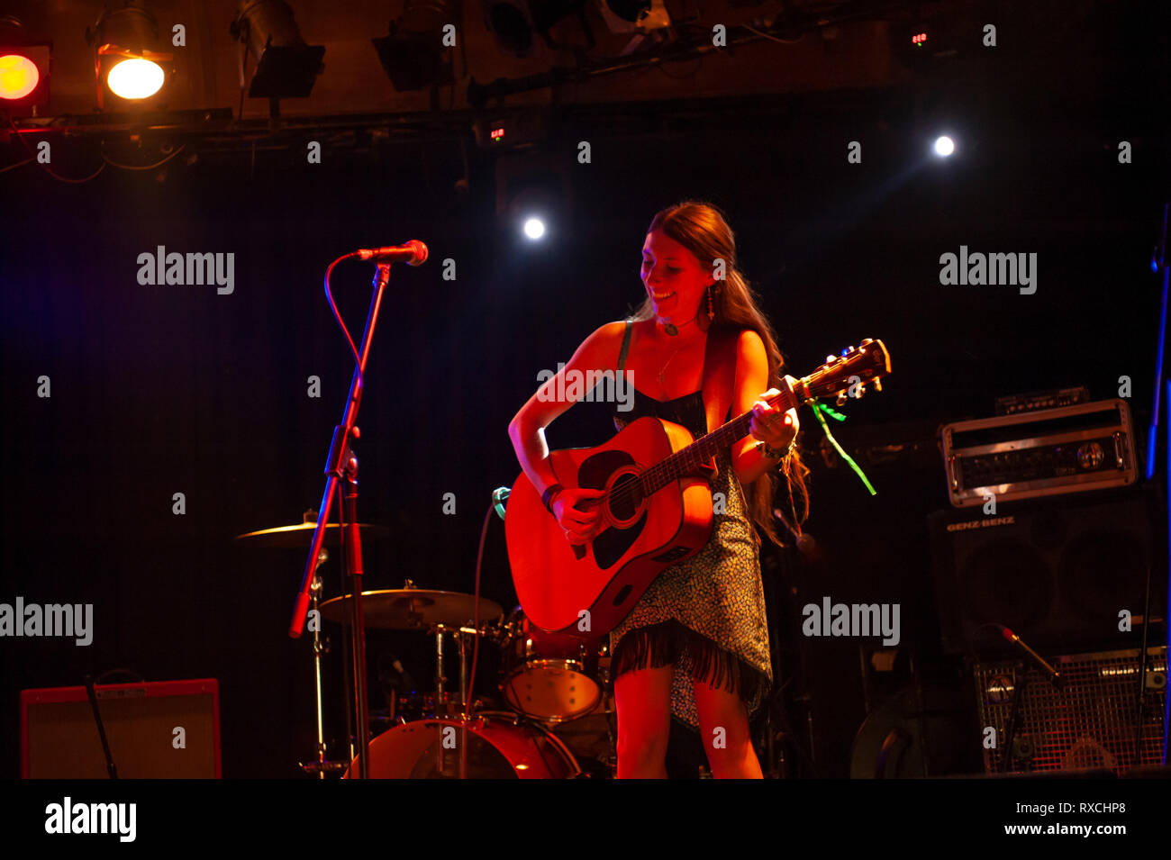 Cantante femminile con la chitarra acustica suonare sul palco Foto Stock