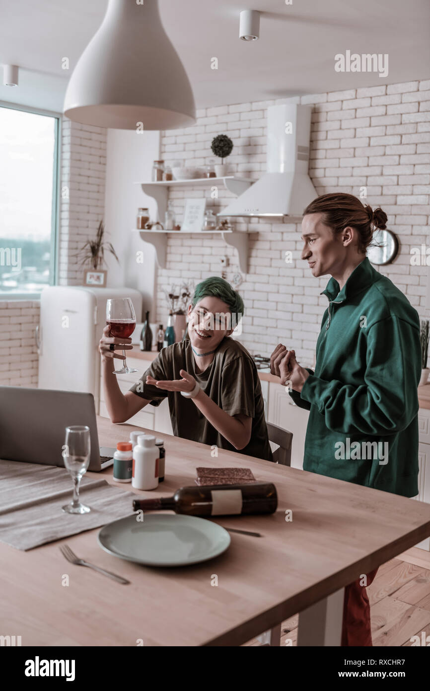 Ragazza trovare scuse mentre il consumo di alcol sul suo proprio Foto Stock