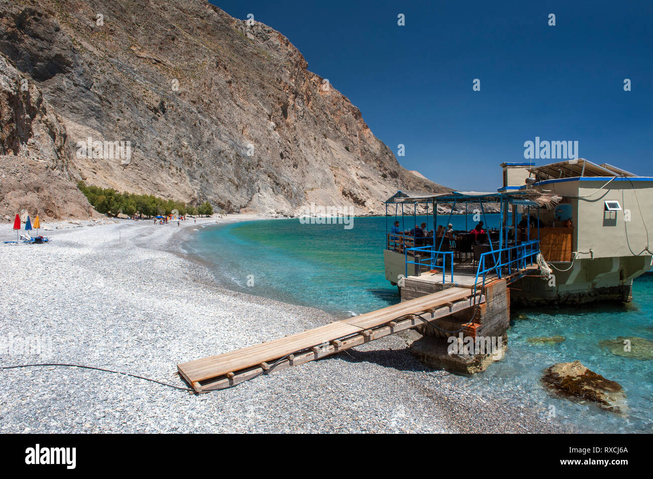 Una taverna costruita su rocce nel mare a Sweetwater Beach, tra Hora Sfakion e Loutro sulla costa meridionale di Creta. Foto Stock