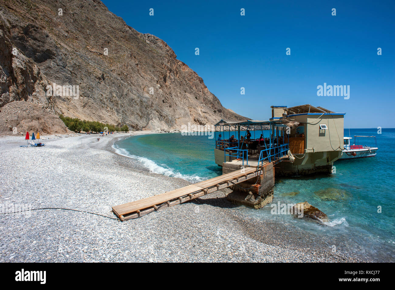 Una taverna costruita su rocce nel mare a Sweetwater Beach, tra Hora Sfakion e Loutro sulla costa meridionale di Creta Foto Stock