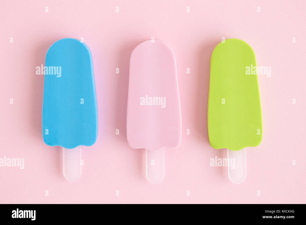 Piatto di laici colorato in miniatura di gelato isolato sul rosa pastello minima di sfondo concetto creativo. Foto Stock