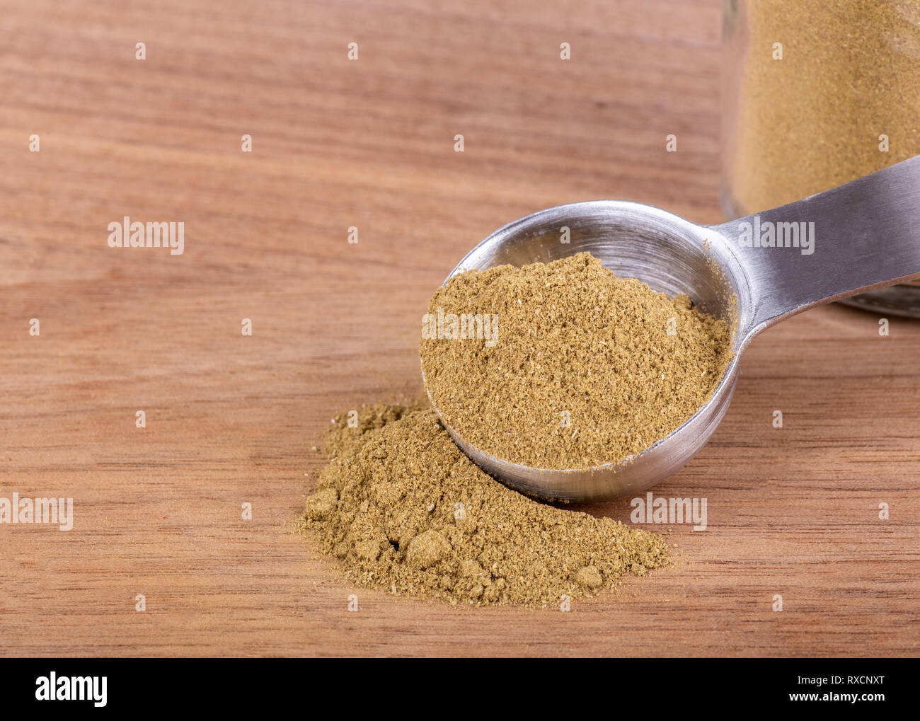 Primo piano della terra la maggiorana e il misurino su una tavola di legno con spazio di copia Foto Stock