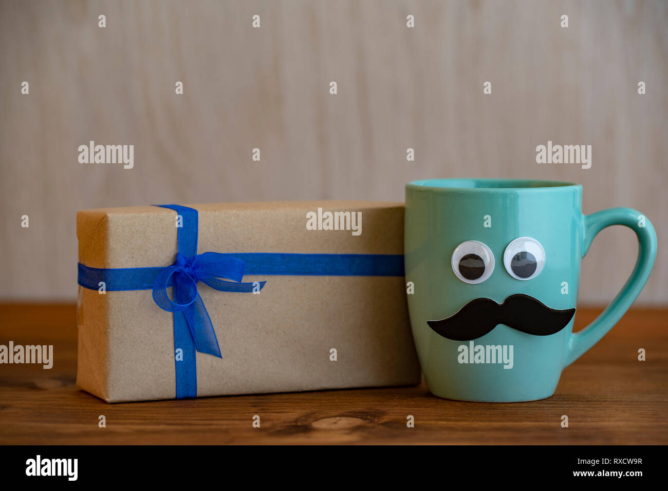 Felice giorno padri concetto con tazza di caffè, baffi e confezione regalo su sfondo di legno Foto Stock