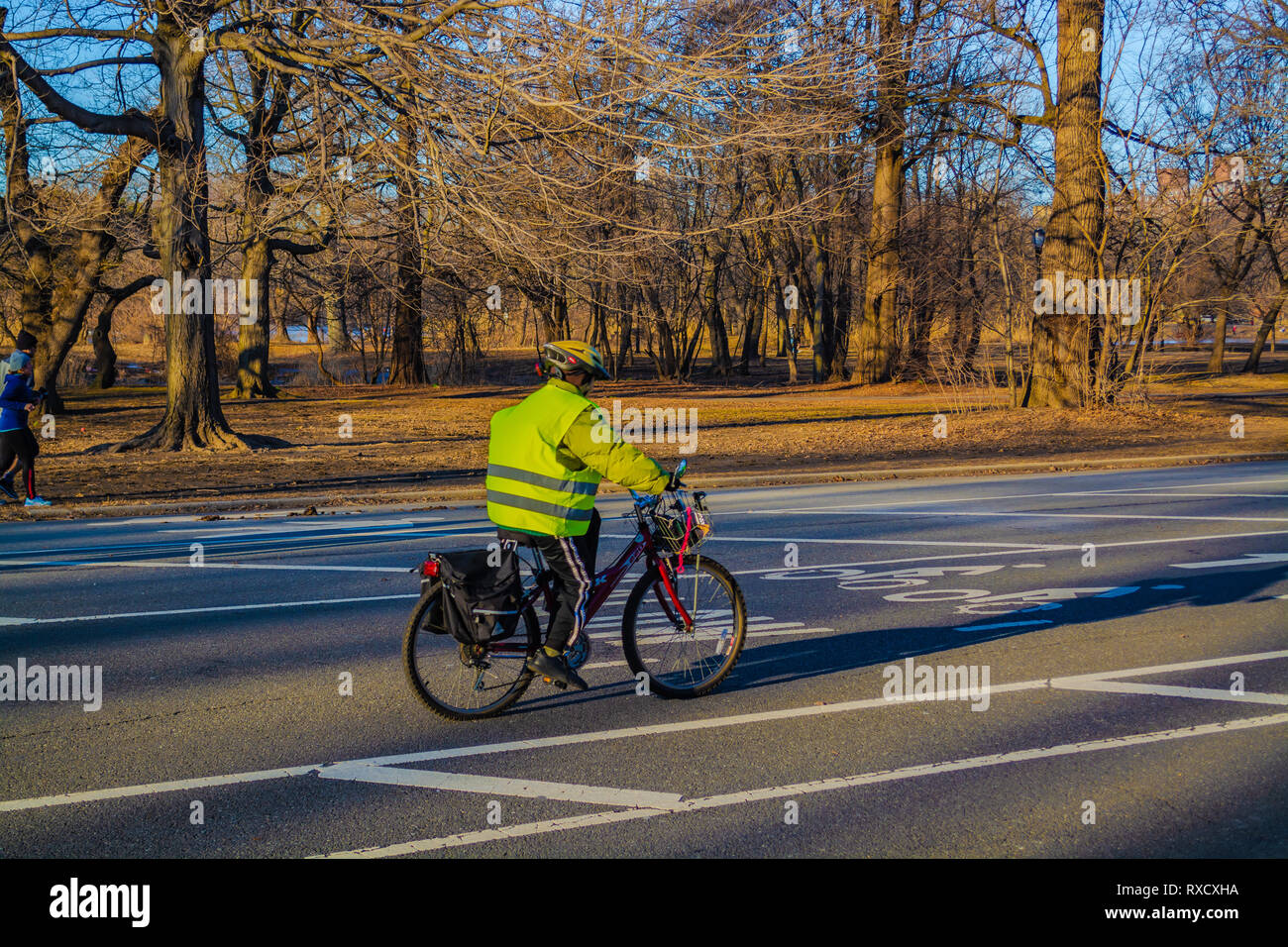 L uomo indossa giubbotto verde equitazione Bicicletta sul Prospect Park road a Brooklyn New York, Febbraio Foto Stock