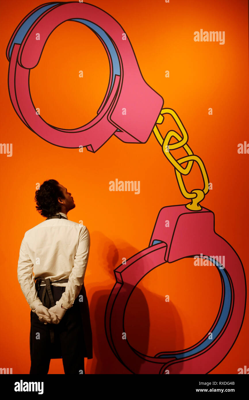 Londra, Regno Unito. 8 Mar 2019. Un Christie's dipendente pone con illustrazioni, precedentemente di proprietà della cantante-cantautore George Michael, "manette' da Michael Craig-Martin (dietro) a casa d'aste Christie's di Londra, Regno Unito, Venerdì, Marzo 08, 2019. Il pezzo fa parte di George Michael serata di raccolta e asta online la prossima settimana. Esso è stimato per ottenere un prezzo massimo di 50.000 sterline rispettivamente fotografia : © Luca MacGregor Credit: Luke MacGregor/Alamy Live News Foto Stock